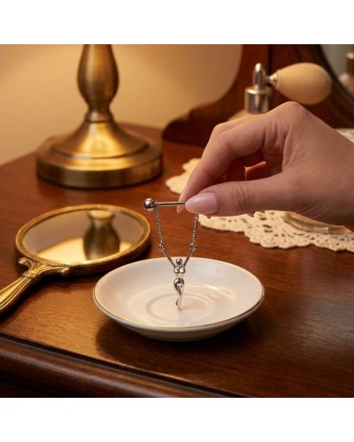 Piercing téton femme en acier chirurgical avec bijou suspendu silhouette féminine sur plateau velours bordeaux